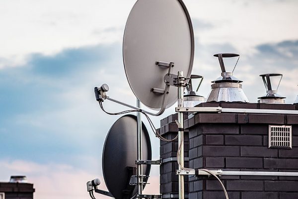 Satellite dishes, satellite antennas mounted on the chimney of a new home. Evening